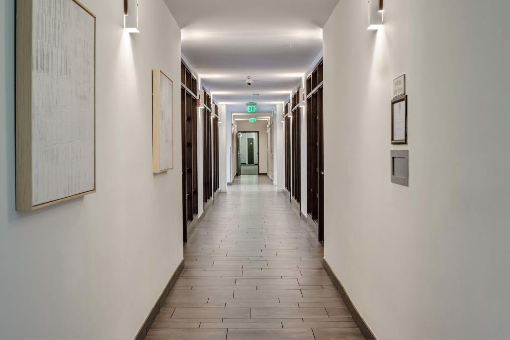 Apartment hallway with smooth eggshell white walls and crisp semi-gloss trim by a painting company in Oahu, HI
